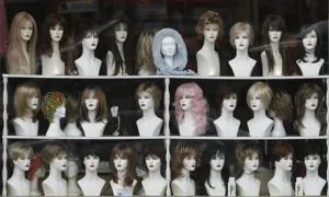 Historical wigs displayed in a glass case