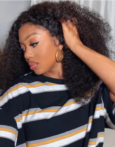 A close-up of a curly lace wig showing the lace front and natural curls