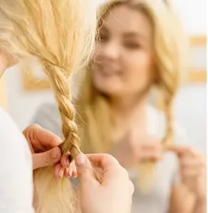 A person putting on a wig cap, ensuring it is snug and secure